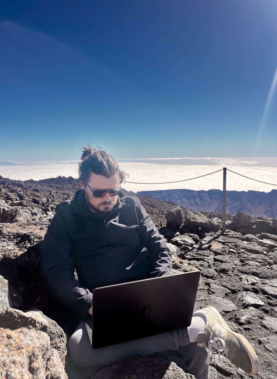 Jed Frankowski working on a laptop in the mountains